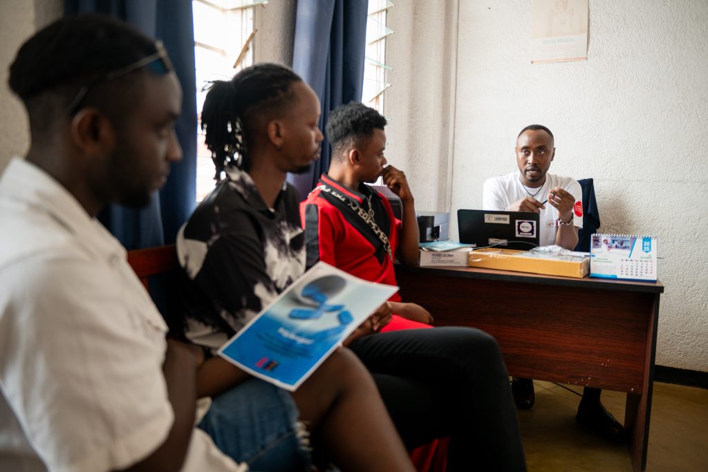 Bujumbura, Burundi, le 17 novembre 2025 : Reportage pour Coalition Plus sur la prise en charge du VIH au Burundi. Immersion auprès des équipes de l’Association Nationale de Soutien aux Séropositifs et malades du sida (ANSS santé PLUS) à l'antenne de Bujumbura centre Turiho. Sur l’image Thibaut, responsable du projet HSH assure une séance de sensibilisation communautaire. Il s’entretient avec (de G.à D.) Dacosta, 29 ans, Alvin, 27 ans et Lavy, 27 ans sur la PrEP.