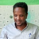 Picture of Yusuf ALI sitting at his desk