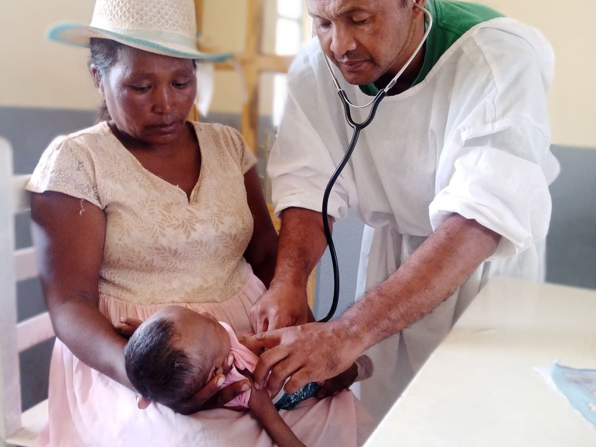 Un médecin examinant avec un stétoscope un bébé tenu par sa mère