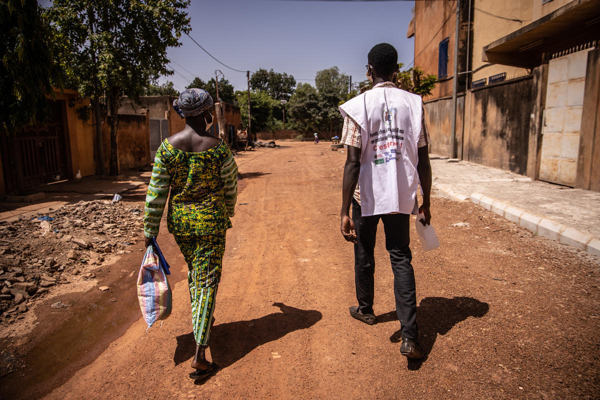Health workers Élise Simporé (L) and F. Ariel Ouedraogo (R), walk door to door to distribute Seasonal Malaria Chemoprevention (SMC), in Ouagadougou on October 12, 2020. 